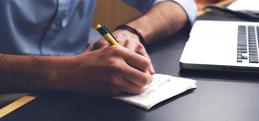 Hombre escribiendo en cuaderno.