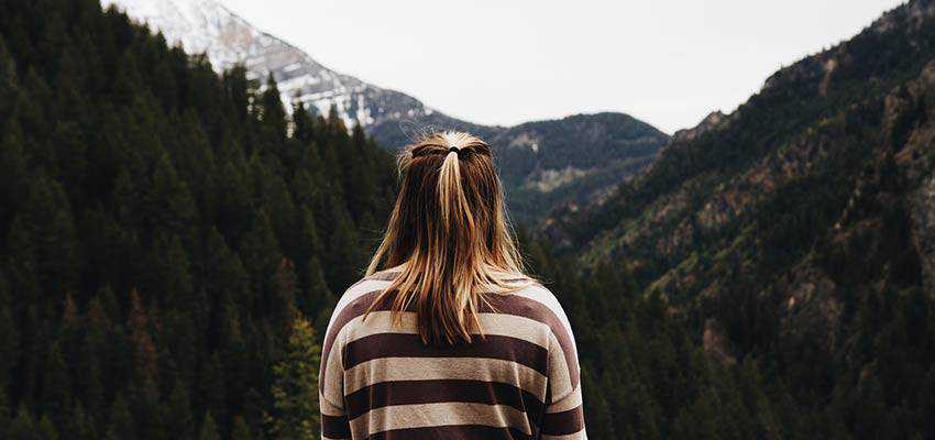 Una mujer mirando a un bosque.