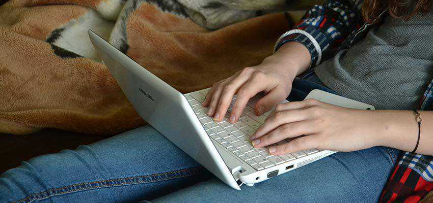 Mujer escribiendo en una computadora portátil.