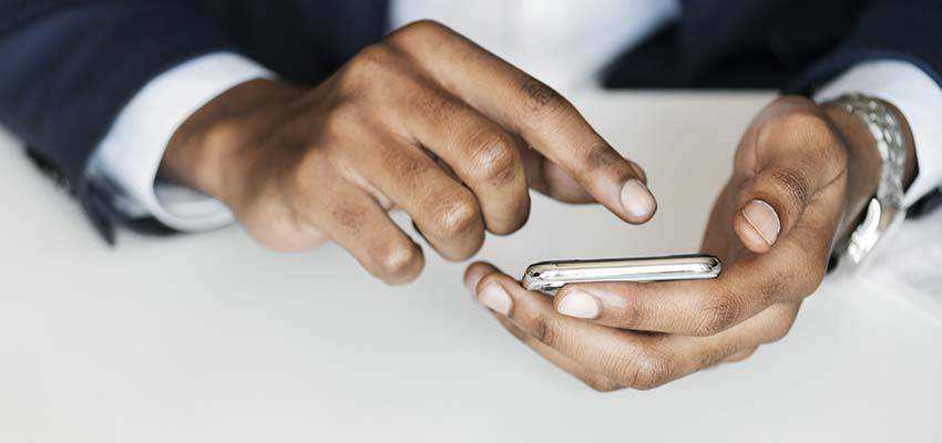 Hombre apuntando a un teléfono inteligente.