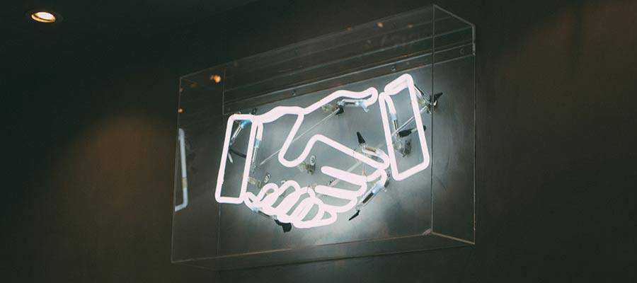 Un'insegna al neon raffigurante una stretta di mano.