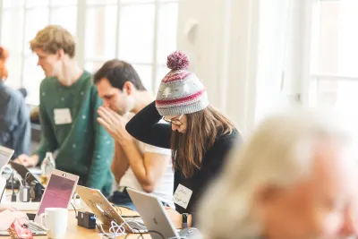 Ana Rodrigues'in önceki bir IndieWebCamp'ta arka planda diğer katılımcılarla kendi bloglarında çalışırken çekilmiş bir fotoğrafı