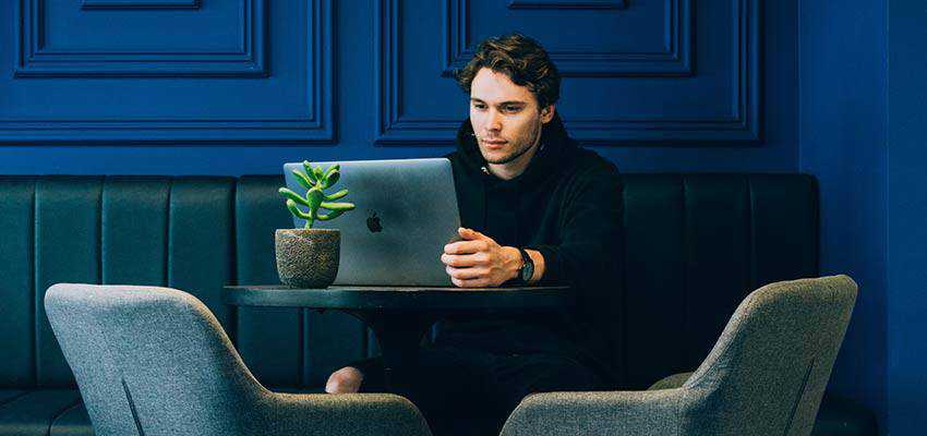 Un hombre mirando una computadora portátil.