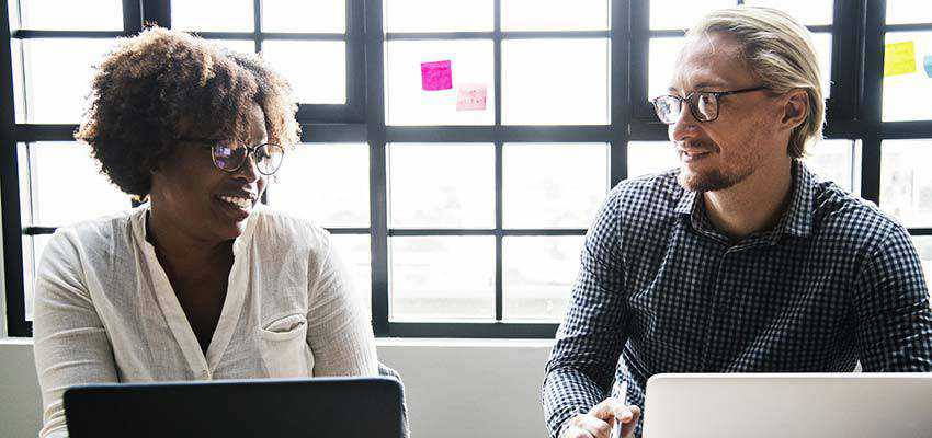 Une femme et un homme assis à un bureau.