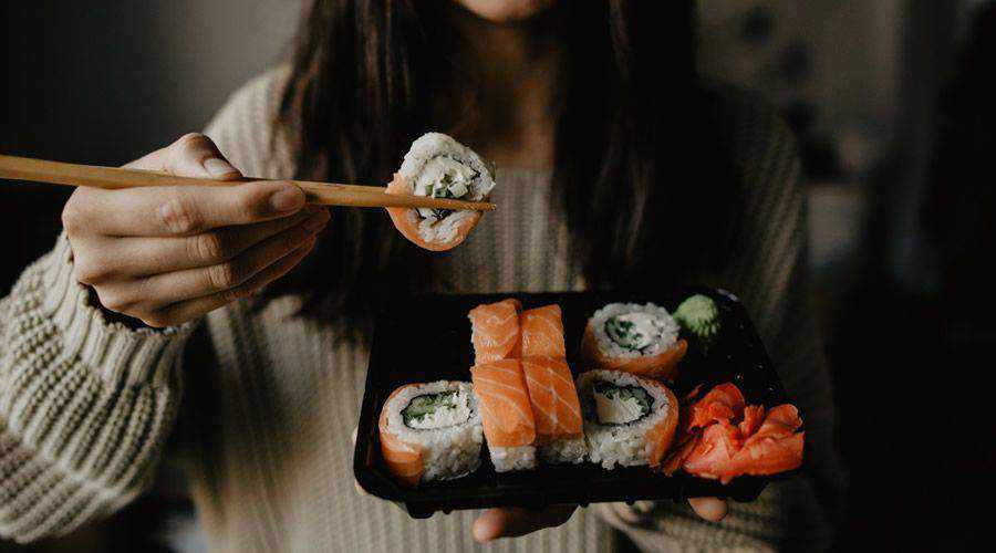 femme mangeant une assiette simple de sushi