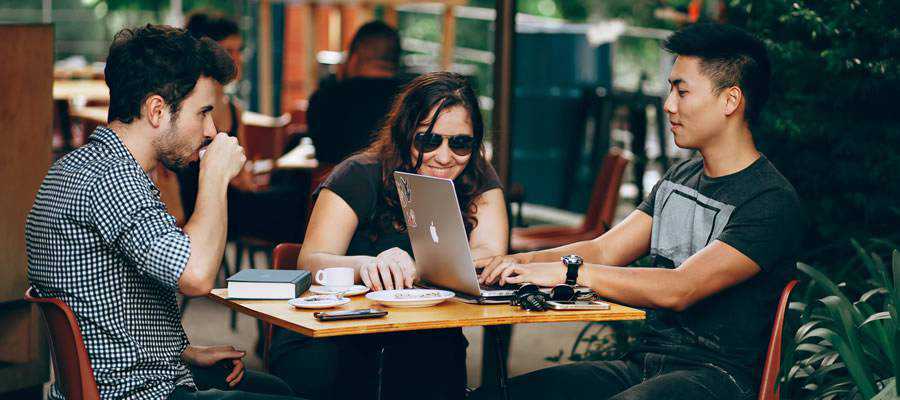 computador de reunião de pessoas fora do café