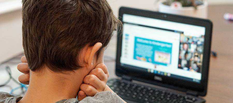 Un bambino che guarda lo schermo di un computer.