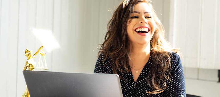 Une femme assise à un bureau et souriant.