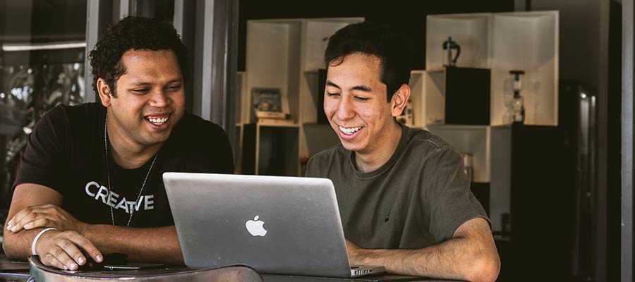 Deux hommes regardent un écran d'ordinateur.