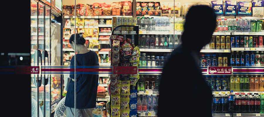 Pessoas fazendo compras em uma loja de conveniência.