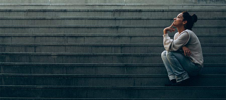 Une femme réfléchit à ses pensées alors qu'elle était assise dans les escaliers.